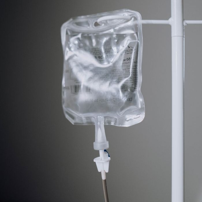 service-1-1 A close-up view of an IV fluid bag hanging on a pole, ideal for healthcare concepts.